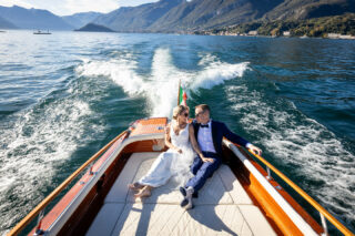 bride and groom in boat on lake como