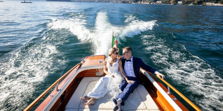 bride and groom in boat on lake como