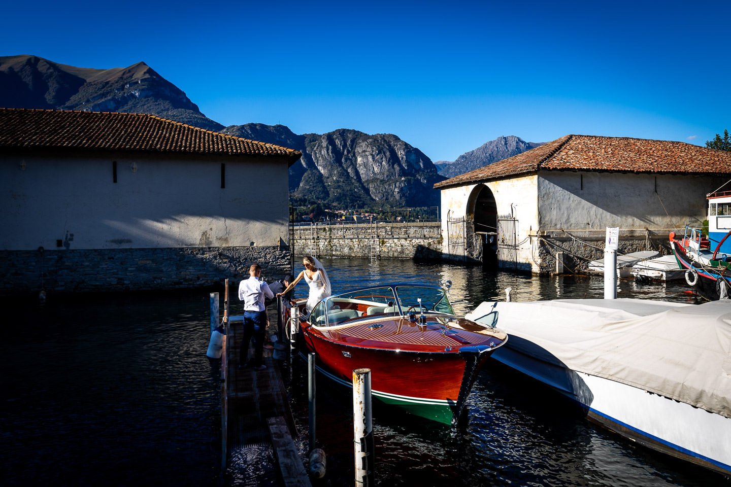 bride and groom in boat on lake como