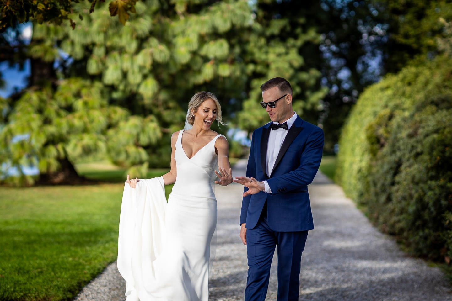 bride and groom looking at the wedding rings walking on villa melzi park