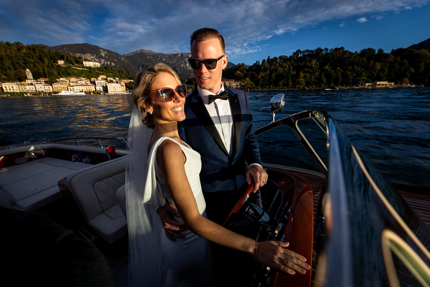 bride and groom in boat on lake como