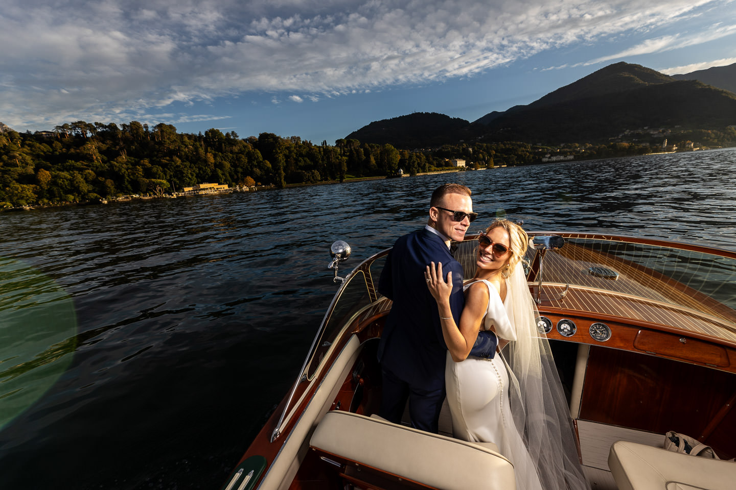 bride and groom in boat on lake como